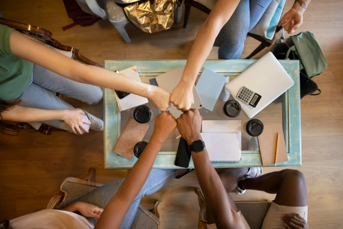 A group of people holding hands over a table